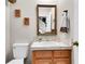 Simple bathroom with wood vanity, large mirror, and toilet at 13 Charlyn Dr, Charleston, SC 29407