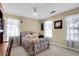 Bright bedroom with floral bedding, two windows, and carpeted floor at 13 Charlyn Dr, Charleston, SC 29407