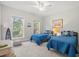 Bright bedroom has 2 twin beds, side table with a lamp, and large windows letting in natural light at 8272 Palmetto Rd, Edisto Island, SC 29438