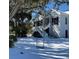 Charming home in the snow features a swing, classic design, and is set amidst mature, picturesque snow covered trees at 8272 Palmetto Rd, Edisto Island, SC 29438