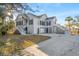 Charming raised beach home with beautiful landscaping, a swing, and ample parking under a clear blue sky at 8272 Palmetto Rd, Edisto Island, SC 29438