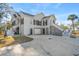 Stunning home with a white exterior, black shutters, elevated on pilings with ample parking and multiple staircases at 8272 Palmetto Rd, Edisto Island, SC 29438