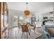 Bright dining room leading into a kitchen with white cabinets, stainless steel appliances, and modern blue backsplash at 8272 Palmetto Rd, Edisto Island, SC 29438