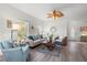 Well-lit living room with cozy furniture, hardwood floors, and large windows with natural light at 8272 Palmetto Rd, Edisto Island, SC 29438