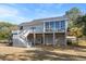 Rear exterior of home with multi-level decks, sunroom and covered ground level at 8272 Palmetto Rd, Edisto Island, SC 29438