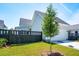 A view of the home's garage with adjacent green yard and black privacy fence at 450 Ripple Park Dr, Summerville, SC 29486