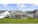 Back view of a house with a patio and lush green lawn in a well-manicured backyard at 133 Summerwind Dr, Summerville, SC 29486