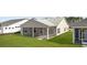 Back view of a house with a patio surrounded by green grass in a manicured backyard at 133 Summerwind Dr, Summerville, SC 29486