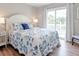 Bedroom with a white bed frame, blue bedding, and sliding door access to a deck at 2 Pelican Reach # Share 10, Isle of Palms, SC 29451