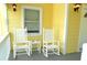 Front porch with rocking chairs and a view of the street at 2 Pelican Reach # Share 10, Isle of Palms, SC 29451