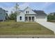 Charming single-story home with light blue siding, white trim, a two-car garage, and a well-manicured front lawn at 732 Breakers Reef Ln, Huger, SC 29450