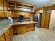 View of the kitchen with wood cabinets, an island, and stainless-steel refrigerator at 1229 Central Ave, Summerville, SC 29483