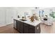 Modern kitchen island with quartz countertops, stainless steel sink, and stylish cabinetry, open to the living area at 223 Abercom Place Dr, Moncks Corner, SC 29461