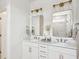 Bright bathroom with double vanity, framed mirrors, modern lighting, and white cabinets at 427 Grove End Rd, Moncks Corner, SC 29461