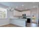 Open-concept kitchen with a breakfast bar, white cabinets, stainless steel appliances, and contemporary lighting at 427 Grove End Rd, Moncks Corner, SC 29461