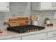 Sleek cooktop with a modern cutting board and utensils on white countertops with gray backsplash at 178 Cantona Dr, Summerville, SC 29483