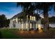 A charming home featuring light gray siding and several windows which illuminate the interior at dusk at 178 Cantona Dr, Summerville, SC 29483