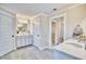 Well-lit bathroom with double vanities, neutral tile flooring, and a separate doorway to the walk-in closet at 163 Seaton Street, Summerville, SC 29486