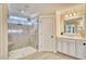 Modern bathroom with a glass-enclosed shower, double vanity with marble countertops, and stylish lighting fixtures at 163 Seaton Street, Summerville, SC 29486
