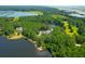 Aerial view of a beautiful, secluded home surrounded by lush greenery, a tranquil lake, and blue skies at 769 Bulls Bay Blvd, Awendaw, SC 29429