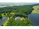 A high angle shot reveals an estate home, pool, golf course, and lake surrounded by mature trees at 769 Bulls Bay Blvd, Awendaw, SC 29429