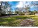 Large backyard with a mix of grass and natural ground cover, enclosed by a wooden fence at 2991 Blackfish Rd, Johns Island, SC 29455