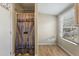 Bathroom features a rustic-style shower curtain and wood-look linoleum floors at 2991 Blackfish Rd, Johns Island, SC 29455