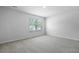 Bright, empty bedroom with plush gray carpeting and natural light from the window at 2172 Macallan Blvd, Ravenel, SC 29470