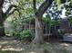 Charming brick home with a screened-in porch, surrounded by mature trees and lush landscaping creating a serene outdoor space at 2320 S Lander Ln, Charleston, SC 29414