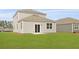 Backyard view of the home featuring a well-manicured lawn and neutral siding at 5536 Bowmore Blvd, Ravenel, SC 29470