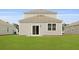 Backyard view showcases sliding glass door access to the home, and a lush lawn at 5536 Bowmore Blvd, Ravenel, SC 29470