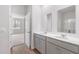 Bright bathroom featuring a double sink vanity with modern fixtures, neutral paint, and a view into an adjacent bedroom at 5568 Bowmore Blvd, Ravenel, SC 29470
