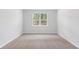 Cozy bedroom featuring neutral carpet, white walls, and a bright window view at 5568 Bowmore Blvd, Ravenel, SC 29470