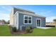 Rear exterior view of a home with vinyl siding, a sliding glass door, a small patio, and green grass at 5568 Bowmore Blvd, Ravenel, SC 29470