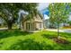 Charming home exterior with well-manicured lawn, established trees, and convenient detached garage at 100 Gray Pine Ln, Summerville, SC 29483