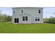 Rear exterior view of a two-story home featuring gray siding and a spacious backyard with green grass at 183 Morning View Way, Moncks Corner, SC 29461
