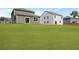 Backyard featuring a green lawn and a view of the house's rear exterior, surrounded by neighboring homes at 355 Willows Crescent Dr, Moncks Corner, SC 29461