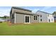 A backyard features a well-kept lawn, showcasing the home's back exterior with a sliding glass door at 355 Willows Crescent Dr, Moncks Corner, SC 29461