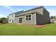 A well-maintained backyard with green grass, showcases the rear exterior of a two-story house at 355 Willows Crescent Dr, Moncks Corner, SC 29461