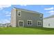 A spacious backyard features lush green grass and a home with blue siding and white trim at 373 Willows Crescent Dr, Moncks Corner, SC 29461