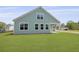Beautiful home exterior with a well-kept lawn, blue siding, and bright windows at 374 Willows Crescent Dr, Moncks Corner, SC 29461