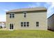 Spacious backyard featuring green grass, sliding glass door, and light green siding at 281 Blue Haw Dr, Moncks Corner, SC 29461