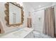 Bright bathroom with a decorative mirror, white countertops, and tiled shower with a patterned curtain at 420 Carolina Cherry Ct # 102, Charleston, SC 29414