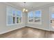 Dining room with wood-look floors, light fixture, and large windows offering natural light at 4 Wappoo Trace Ln, Summerville, SC 29486