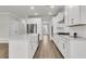 Spacious kitchen features white cabinets, stainless steel appliances, an island, and wood-look flooring at 4 Wappoo Trace Ln, Summerville, SC 29486