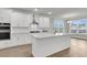 Kitchen with island, white cabinets, stainless appliances, quartz countertops, and wood-look floors at 4 Wappoo Trace Ln, Summerville, SC 29486