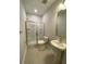 Well-lit bathroom with tiled floors, a glass-enclosed shower, and a pedestal sink at 9 Wappoo Trace Ln, Summerville, SC 29486