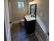 Bathroom featuring wood grain vinyl flooring, single sink, and white trim at 7629 Pinehurst St, North Charleston, SC 29420