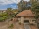 Aerial view of a two story home with a large front deck and lush, tropical landscaping at 818 Club Cottage Court, Edisto Beach, SC 29438