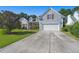 Two-car garage and driveway leading to a gray house with red shutters at 399 Decatur Dr, Summerville, SC 29486